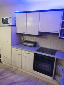 una cocina con armarios blancos y un aparato negro en Appartement Huldange, en Huldange