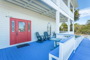 a front porch with a red door and chairs at St George Inn in St. George Island