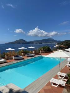 una gran piscina con sillas y sombrillas en Villa Manni en Procida