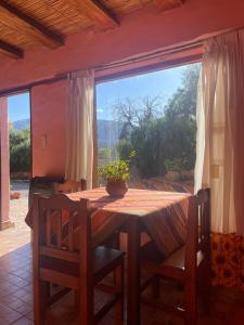 una mesa en una habitación con una ventana grande en Hostería Plaza Chica Tilcara en Tilcara