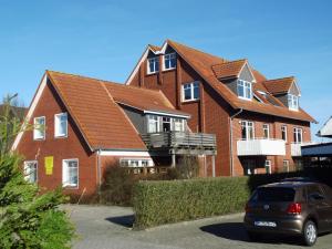 ein großes rotes Backsteinhaus mit Balkon in der Unterkunft Yachthus in Carolinensiel