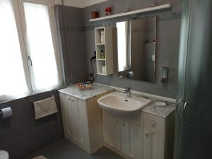 La salle de bains est pourvue d'un lavabo et d'un miroir. dans l'établissement Amore di lago, à Tavernola Bergamasca