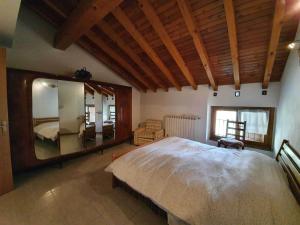 a bedroom with a large bed and a large mirror at Pleasant apartment in Vendrogno with balcony in Regoledo