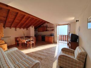 uma sala de estar com mesa e cadeiras e uma cozinha em Pleasant apartment in Vendrogno with balcony em Regoledo