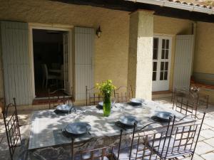 uma mesa com cadeiras e um vaso de flores sobre ela em Charming holiday home in Lorgues with private pool em Lorgues