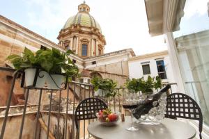un tavolo e sedie su un balcone con un edificio di Quintocanto Hotel & Spa a Palermo