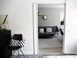 uma sala de estar com um espelho e um sofá preto em Scandinavian Home 17 city Center Työmiehenkatu 2B em Helsinque