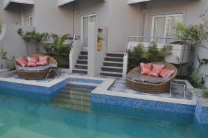 duas cadeiras de vime sentadas ao lado de uma piscina em Pramod Convention & Beach Resorts em Puri