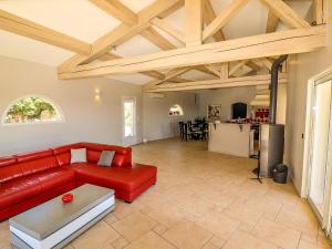 sala de estar con sofá rojo y cocina en Amazing holiday home in Flayosc with private pool, en Flayosc