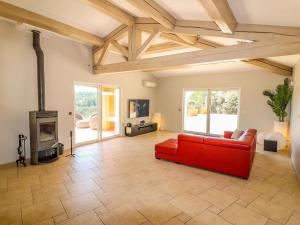 sala de estar con sofá rojo y chimenea en Amazing holiday home in Flayosc with private pool, en Flayosc