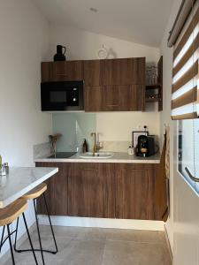 una cocina con armarios de madera y fregadero en Suite La Farigoulette en Marsella