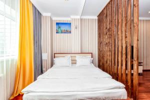 Schlafzimmer mit einem großen Bett mit einem Kopfteil aus Holz in der Unterkunft apartment on the 29th floor in Astana