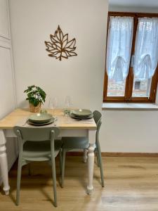 a table with two chairs and a table with glasses at La Foglia in Abbadia San Salvatore