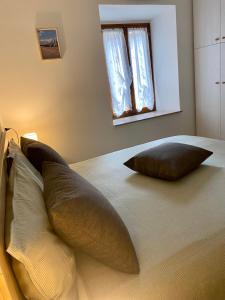 a bed with two pillows on it with a window at La Foglia in Abbadia San Salvatore