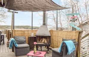 d'une terrasse avec une cheminée, des chaises et une table. dans l'établissement Cozy Home In Trosa With House Sea View, à Trosa