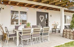 a table and chairs on a patio with a heart on the door at Cozy Home In Trosa With House Sea View in Trosa