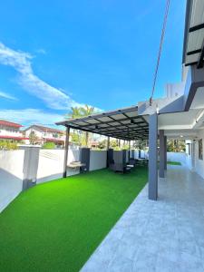 a patio with awning and green grass at Entire Vacation Home with landscape garden in Sitiawan
