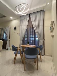uma sala de jantar com mesa e cadeiras em Entire Vacation Home with landscape garden em Sitiawan