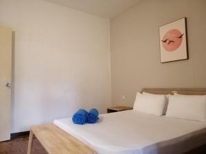 My Cozy Nest - Near Beach في باتو فيرينغي: غرفة نوم عليها سرير وفوط زرقاء