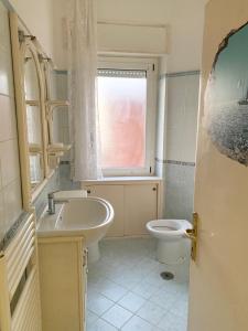 a bathroom with a sink and a toilet and a window at Rosso Tramonto luxury-blu- LADISPOLI, Lungomare Regina Elena 2 in Ladispoli