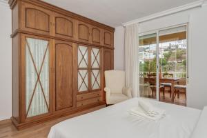 ein Schlafzimmer mit einem Bett, einem Stuhl und einem Fenster in der Unterkunft Rooftop flat in Torreblanca Ref 44 in Fuengirola