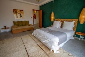 Un dormitorio con una cama grande y una pared verde en Villa L'oui D'or, en Marrakech