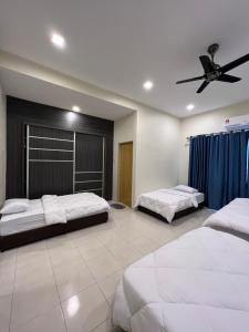 a bedroom with two beds and a ceiling fan at Entire Vacation Home with landscape garden in Sitiawan