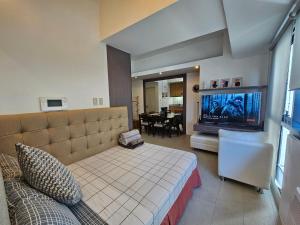 a bedroom with a bed and a flat screen tv at Spacious Studios in Manila