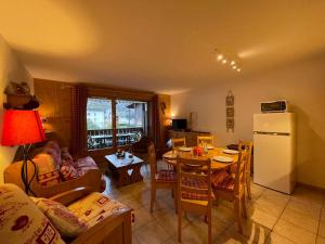 een woonkamer met een tafel en een koelkast bij Appartement Samoëns, 3 pièces, 7 personnes - FR-1-624-19 in Samoëns