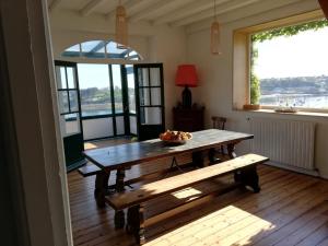 - une table et un banc dans une chambre avec fenêtre dans l'établissement KER HUELLA - Saint-Pabu, à Saint-Pabu