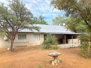 ein Haus mit einer Bank davor in der Unterkunft Kalahari Homestead in Khemsbok