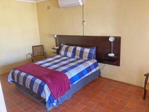 En eller flere senge i et værelse på Kalahari Homestead