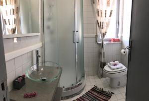 uma casa de banho com uma cabina de duche em vidro e um WC. em Domus Narciso Gallery em Pompeia