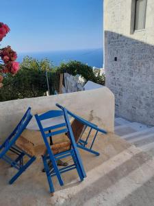 una sedia blu seduta sui gradini di una casa di Oniropagida Nisyros apartment #1 a Nikiá