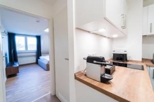 cocina y sala de estar con un aparato en la encimera en JAWO Apartments Koblenz modern & zentral, Küche & WIFI, en Coblenza