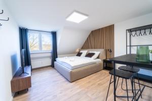 a bedroom with a bed and a desk and a television at JAWO Apartments Koblenz modern & zentral, Küche & WIFI in Koblenz