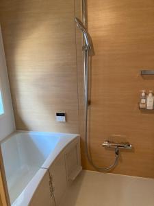e bagno con vasca e doccia. di 宿坊 れんじょう寺 奈良 Temple Stay Renjoji Nara a Nara