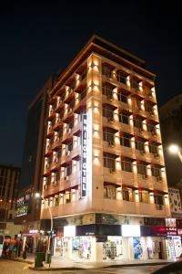 un grand bâtiment avec des lumières allumées la nuit dans l'établissement Rhisos Otel, à Rize