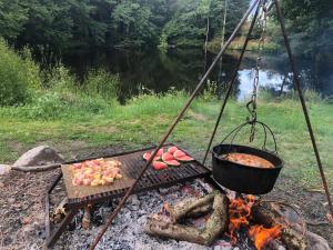 a grill with a pot of food on it next to a river at Accomodatie in Villa Werschmatt in Kruth
