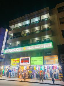 a building with people walking in front of a store at Silver Sand Hotel in Dubai