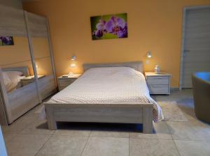 een slaapkamer met een bed met 2 dressoirs en 2 spiegels bij B&B Het Polderhof in Jabbeke