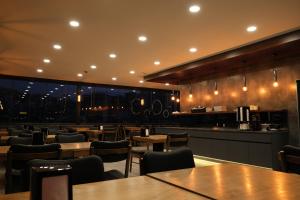 a restaurant with tables and chairs and a bar at Rhisos Otel in Rize