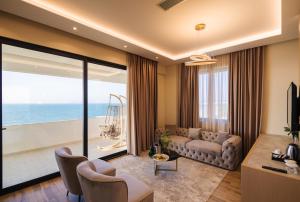 a living room with a couch and a view of the ocean at Gloria Palace Hotel & SPA in Golem