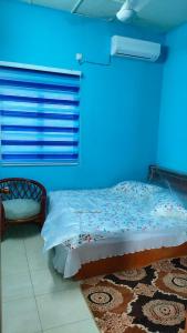 a blue room with a bed and a chair at Che Det Homestay Chemor in Chemor