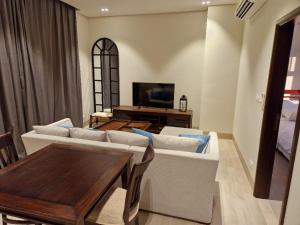 uma sala de estar com um sofá e uma mesa em Glory Salalah Miko 1 em Salalah