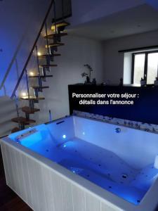 a large blue tub in a room with a staircase at Ecrin de bien-être au pays des couleurs in Saint-Victor-de-Morestel