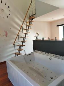 a large white bath tub in a room with stairs at Ecrin de bien-être au pays des couleurs in Saint-Victor-de-Morestel