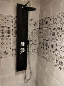 a shower with a black shower head in a bathroom at Ecrin de bien-être au pays des couleurs in Saint-Victor-de-Morestel