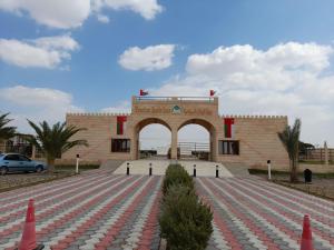 un edificio con un arco delante de él en بوابة الرمال السياحية Tourism sands gate, en Al Wāşil