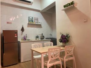 a kitchen with a table and chairs and a refrigerator at Lovely 1-Bedroom Condo with Facilities in Melaka